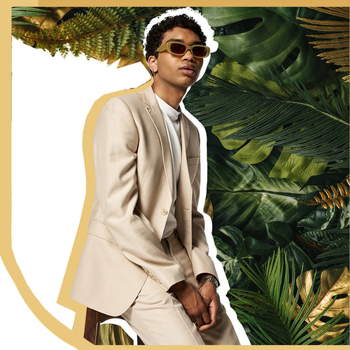 young chic blang guy in sunglassea with exhuberant plant background